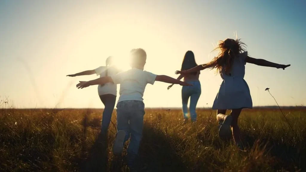 Imagem criancas felizes com os bracos abertos ao ar livre do artigo 3 maneiras de ser sinal de esperança no mundo ao nosso redor