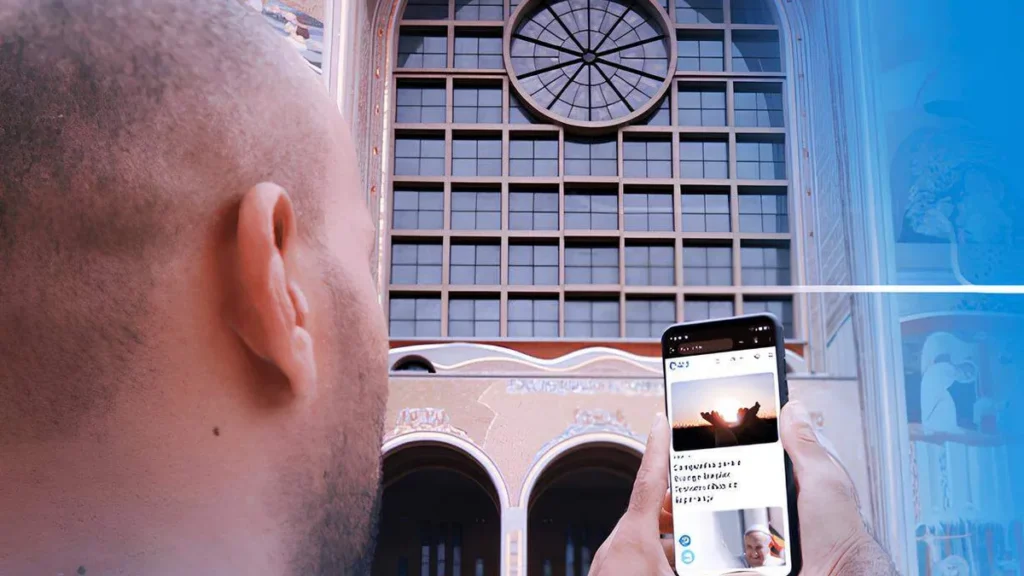 Imagem homem mexendo no celular em frente ao santuario nacional do artigo A12: 15 anos conectado com você pela fé