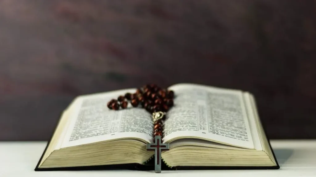 Imagem Biblia aberta com um rosario dobre ela do artigo Músicas para a celebração do Domingo da Palavra do Senhor