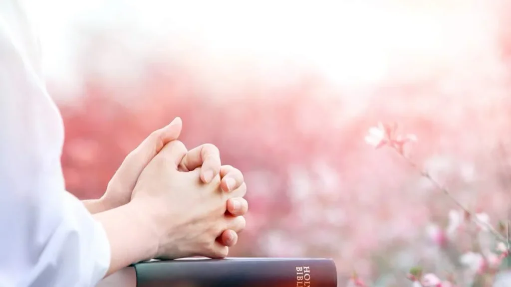 Imagem maos rezando sob a Biblia do artigo Renove sua fé e permita que Deus guie seus passos