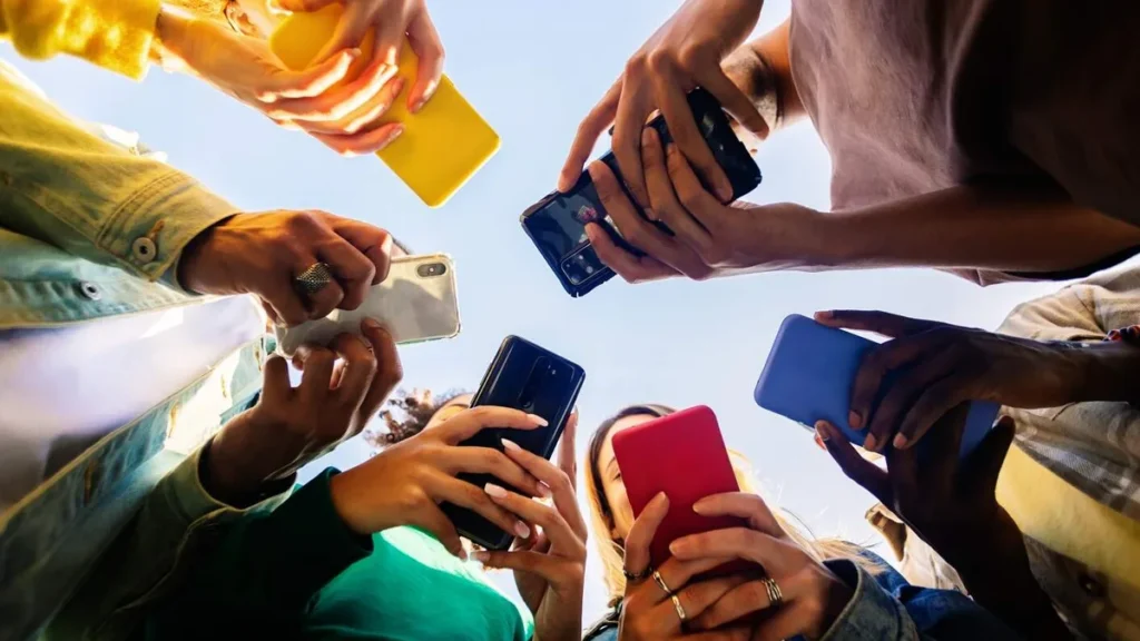 Imagem pessoas segurando celulares em roda de baixo pra cima do artigo Dia da Internet Segura: o olhar da Igreja Católica