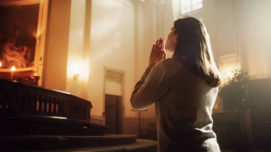 Imagem mulher rezando na igreja do artigo Quaresma: a paz vem de Deus e do amor fraterno