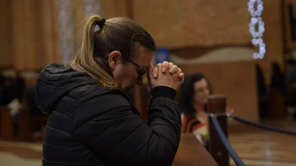 Imagem Mulher rezando com as maos proximas ao rosto do artigo Indulgência Plenária: renove sua alma no Ano Santo