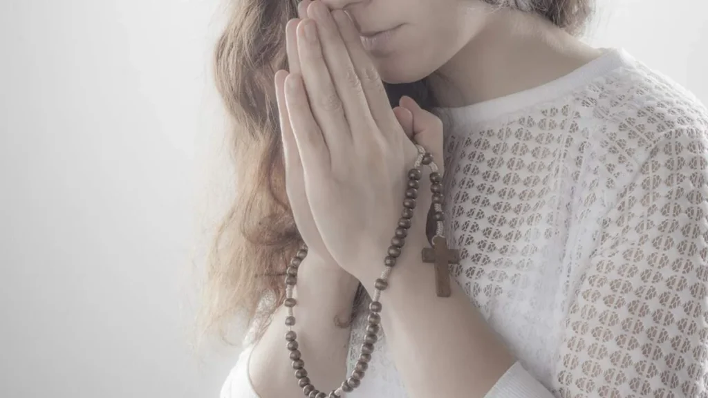 Imagem Mulher rezando o terco do artigo Você sabe a importância da oração do Santo Terço Mariano?