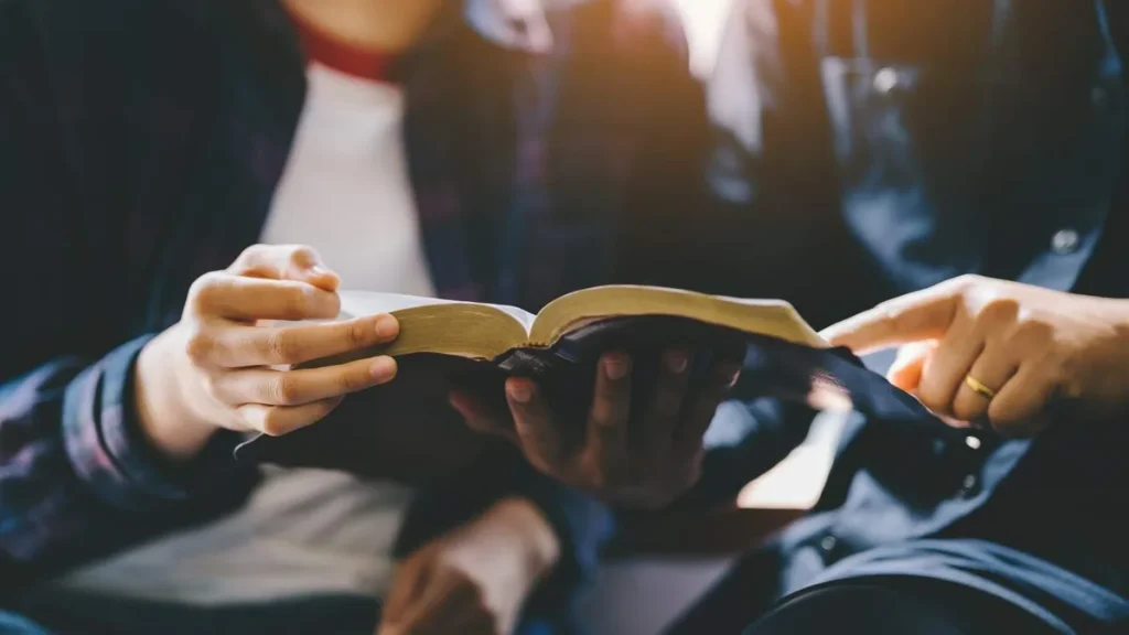 Imagem duas pessoas lendo a mesma biblia do artigo Por que há diversas traduções para a Bíblia no mesmo idioma?