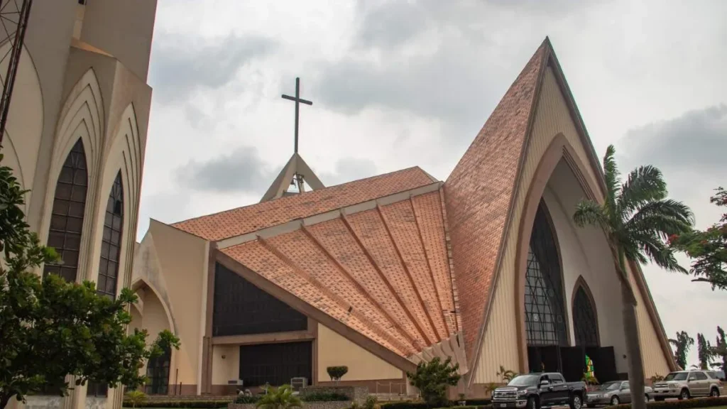 Imagem Exterior com arcos cruzes e paredes decorativas da igreja catolica em Abuja a igreja e conhecida como Centro Cristao Nacional anteriormente conhecido como Centro Ecumenico Nacional na Nigeria do artigo Perseguição cristã na Nigéria: dor e resistência