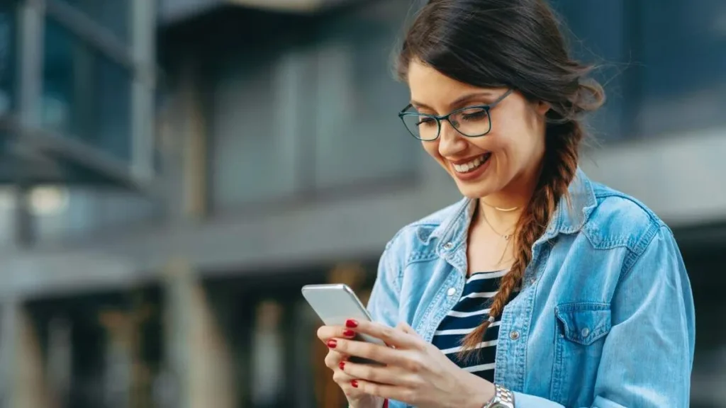 Imagem mulher mexendo no celular do artigo Caridade na troca de mensagens: gestos que evangelizam