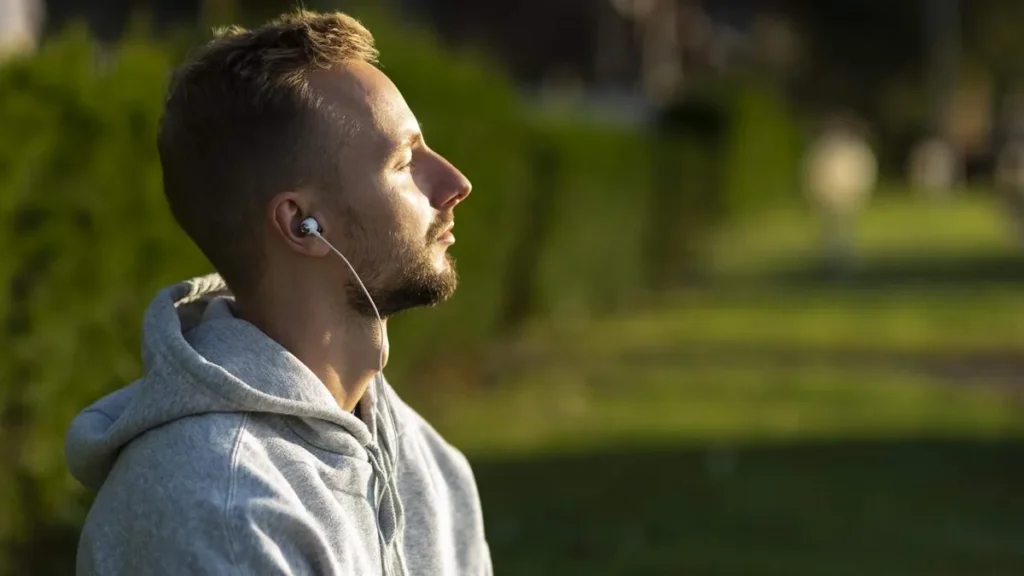 Imagem Homem com fone de ouvido pensando e escutando musica do artigo Saúde mental do homem: o silêncio que também adoece