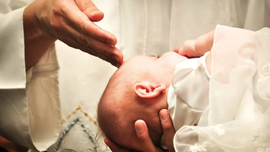 Imagem Maos de um sacerdote sob a cabeca de um bebe no ato do batismo do artigo Sacramentos da Santa Igreja: tire suas dúvidas sobre o Batismo
