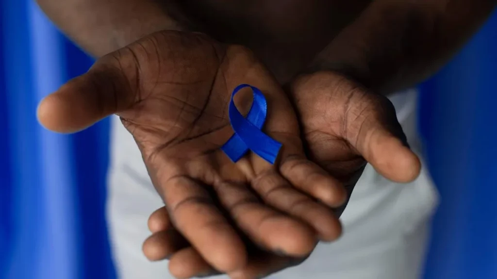Imagem mao negra segura fita azul de novembro azul do artigo Vida Saudável: tire todas as suas dúvidas sobre novembro azul