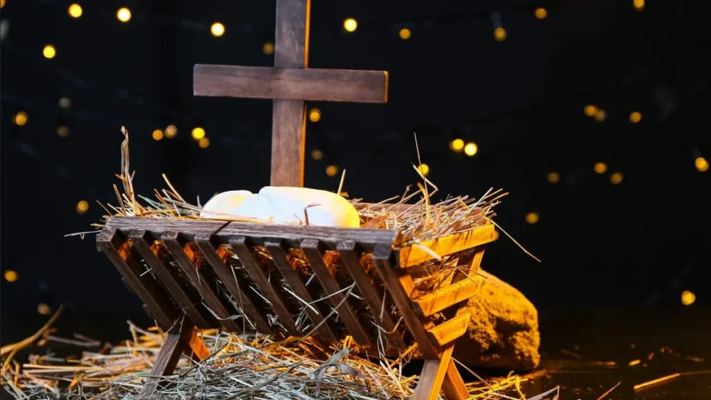 Imagem manjedoura de jesus com a cruz no fundo do artigo Por que o Natal já anuncia a Paixão de Cristo?