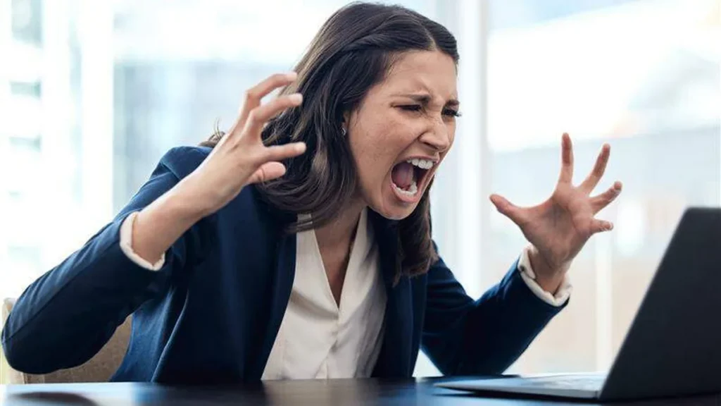 Imagem Mulher gritando para o computador do artigo O perigo de agir com raiva no ambiente digital