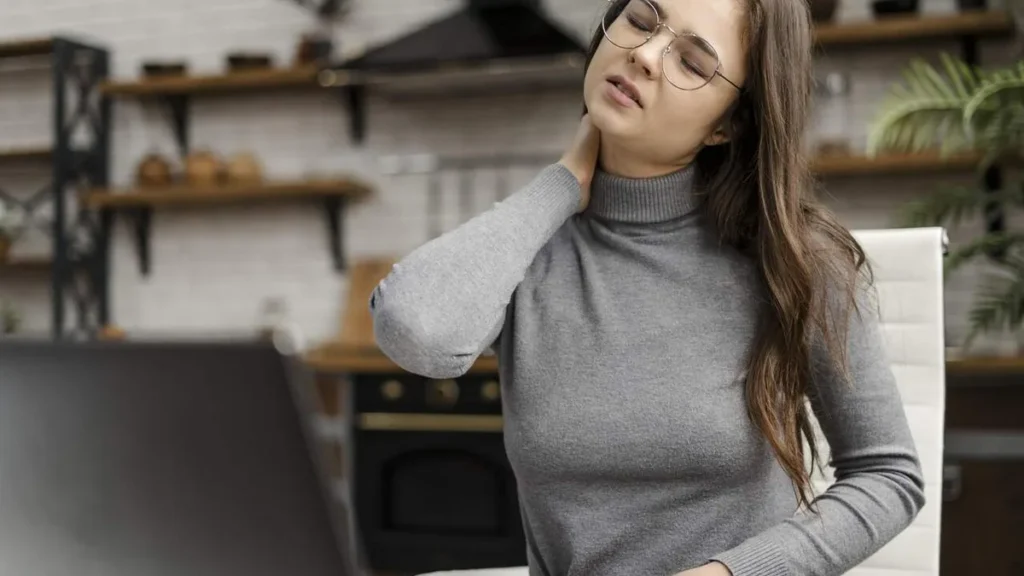 Imagem mulher jovem com dor de cabeca enquanto trabalha em casa Easy Resize.com do artigo Dor no pescoço: quando é preciso investigar?