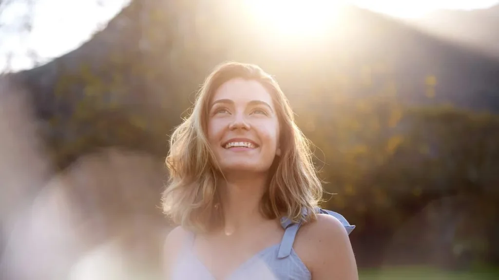 Imagem mulher olhando para cima sorrindo natureza do artigo Afinal, o que aprendemos sobre a esperança no Ano Jubilar?
