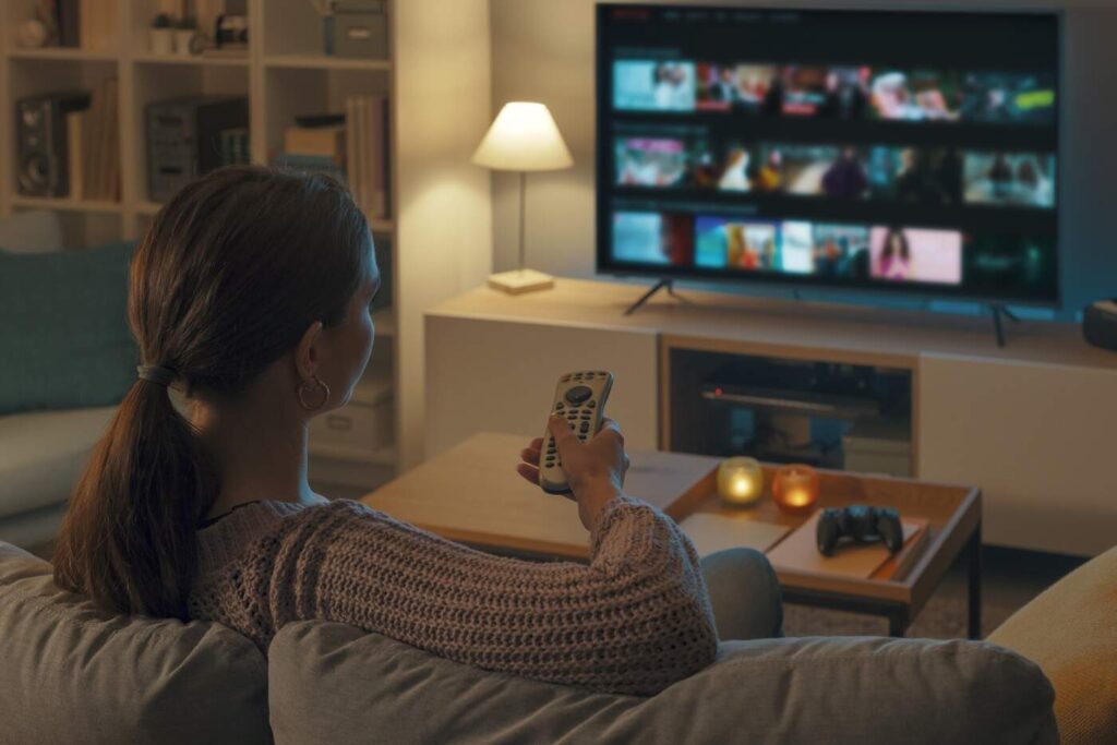 mulher escolhendo o que assistir nos streamings de filme (StockPhotoPro/Adobe Stock)