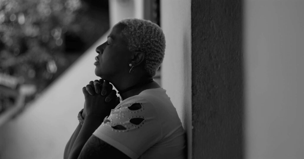 mulher reza com fé com as mãos postas e olhos fechados (Marco/Adobe Stock)