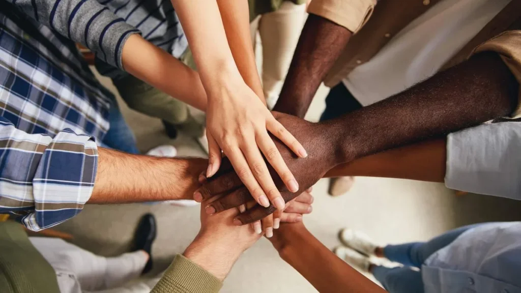 Imagem pessoas com as maos unidas de diferentes etnias do artigo Como os valores são formados e influenciam a sociedade?