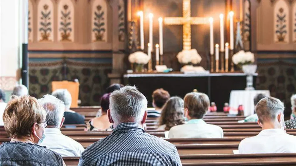 Imagem pessoas rezando na igreja do artigo Acolhidos pela Igreja: quando uma família tem a vida transformada