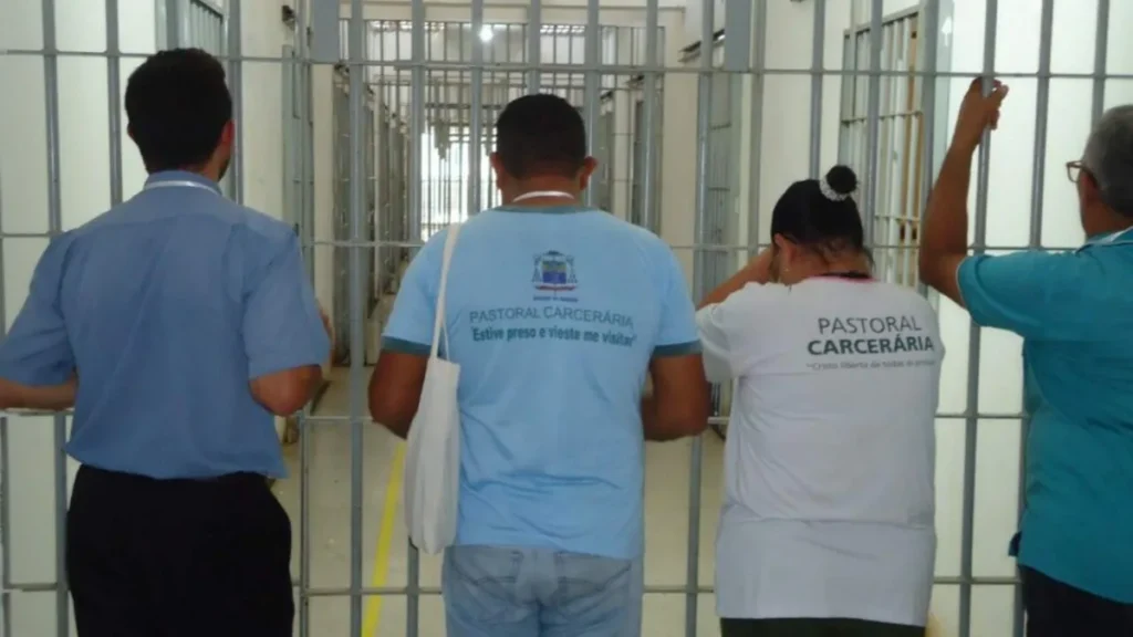 Imagem Membros da Pastoral Carceraria rezando com as maos na grade do artigo O trabalho da Pastoral Carcerária na busca pela justiça e paz