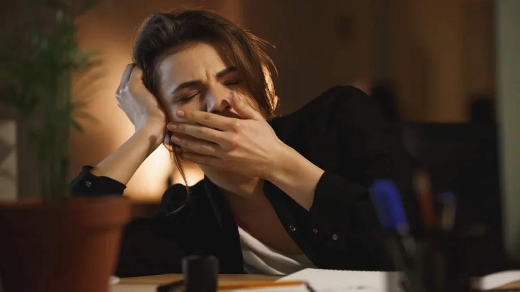 Imagem Mulher com sono no ambiente de trabalho do artigo Cansaço o dia todo? Seu corpo pode estar pedindo ajuda