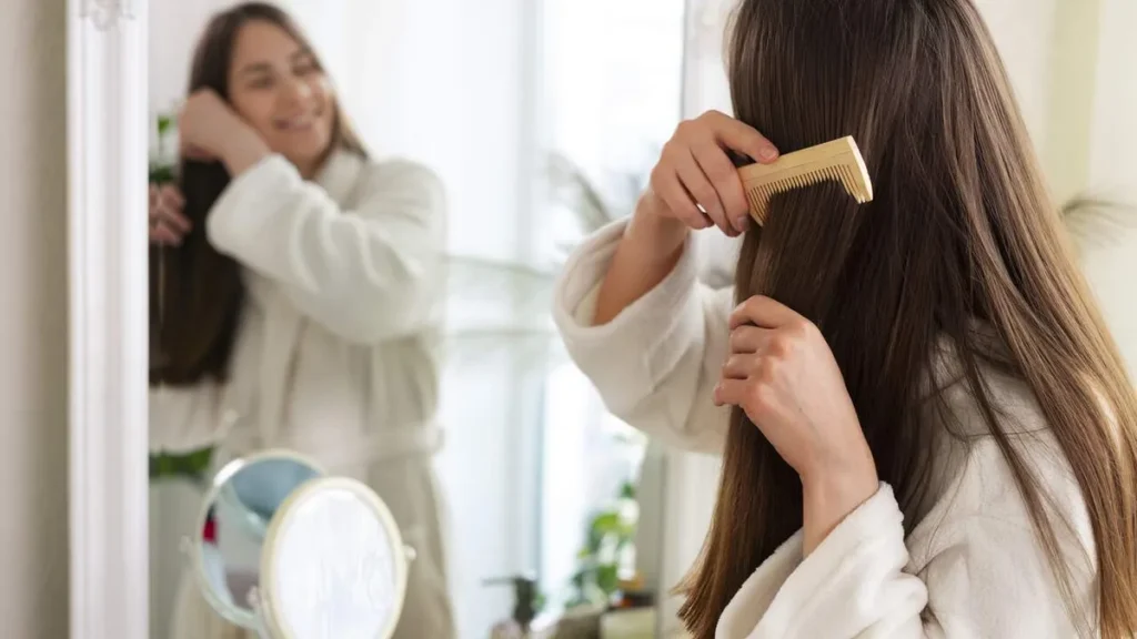 Imagem Mulher penteado os fios de cabelo do artigo Como proteger os fios e o couro cabeludo no verão?
