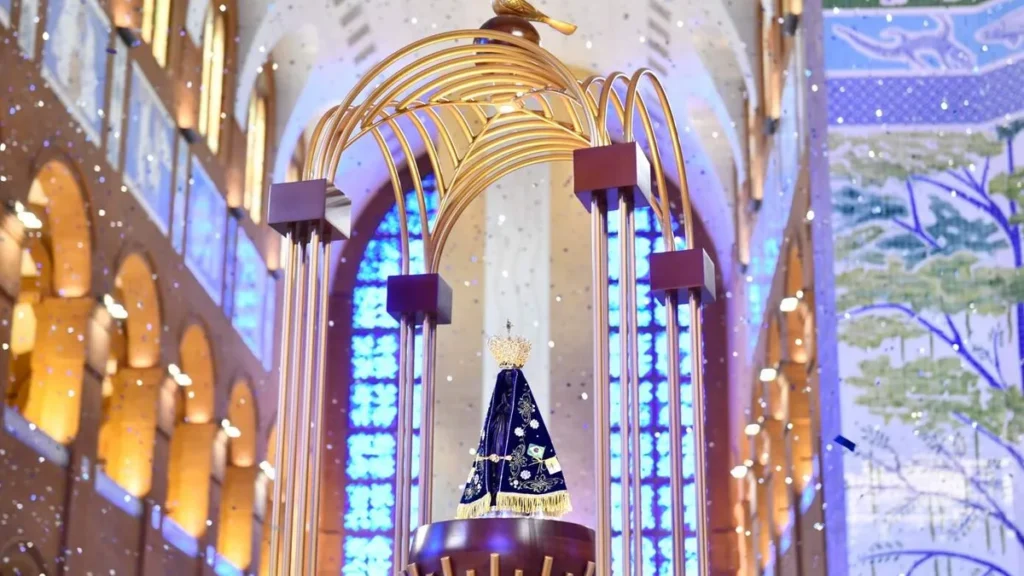 Imagem Trono de Nossa Senhora com papeis brilhantes caindo atras do artigo Conheça o tema da Novena da Padroeira deste ano
