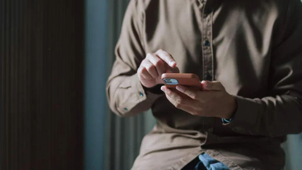 Imagem maos de home segurando o celular do artigo Mistérios da Fé: como se desconectar em um mundo hiperconectado