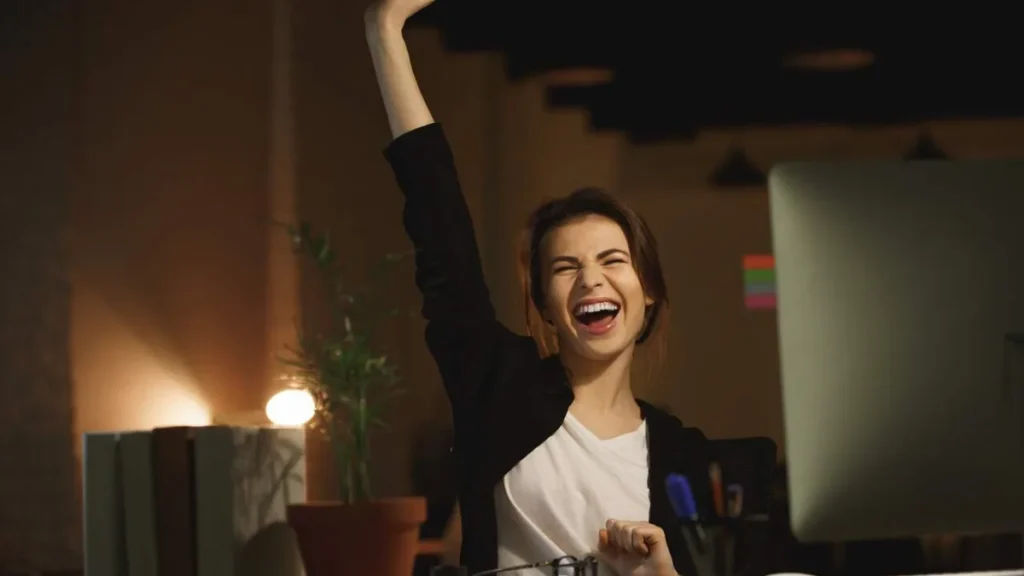 Imagem Mulher feliz com uma conquista em sua carreira profissional do artigo Os primeiros passos para uma carreira de sucesso