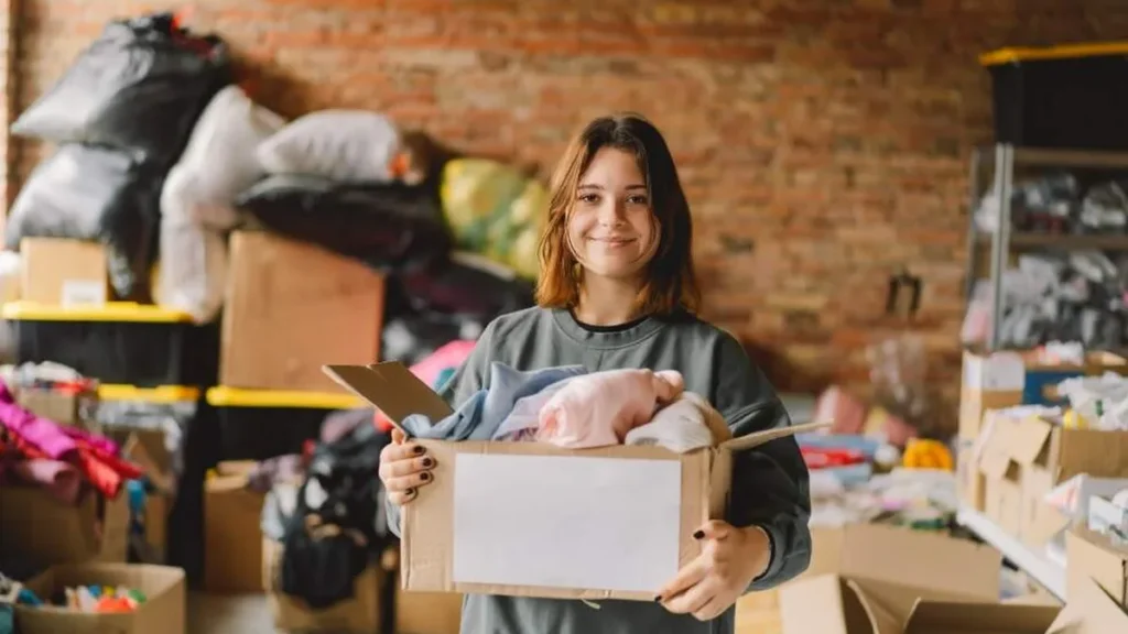 Imagem Mulher segurando um acaixa com roupas para serem doadas do artigo Mistérios da fé: dicas para viver o aspecto social da Quaresma