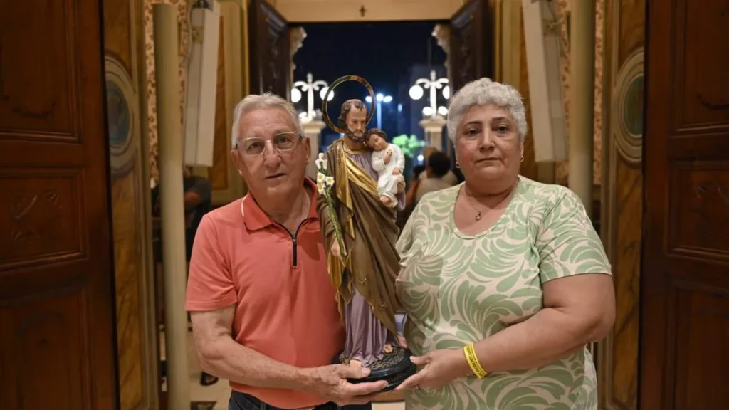 Imagem casal segura a imagem de sao jose para adentrar no altar durante novena de sao jose 2026 do artigo Novena de São José começa e reflete sobre o matrimônio