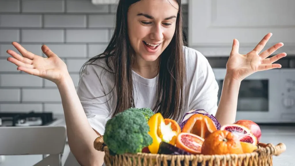 Imagem Mulher feliz com os alimentos para uma refeicao saudavel do artigo Alimentação Consciente: um ato de amor-próprio