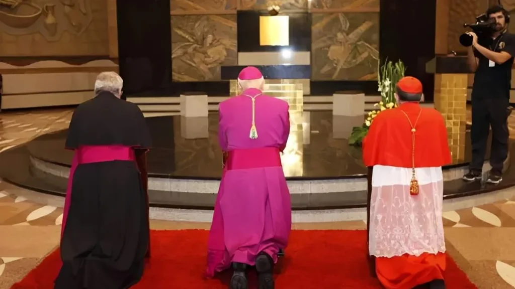 Imagem posse canonica de dom orlando a frente da arquidiocese de aparecida em 2027 ele ajoelhado com dom damasceno e o nuncio apostolico do artigo Como funciona a posse canônica de um arcebispo?