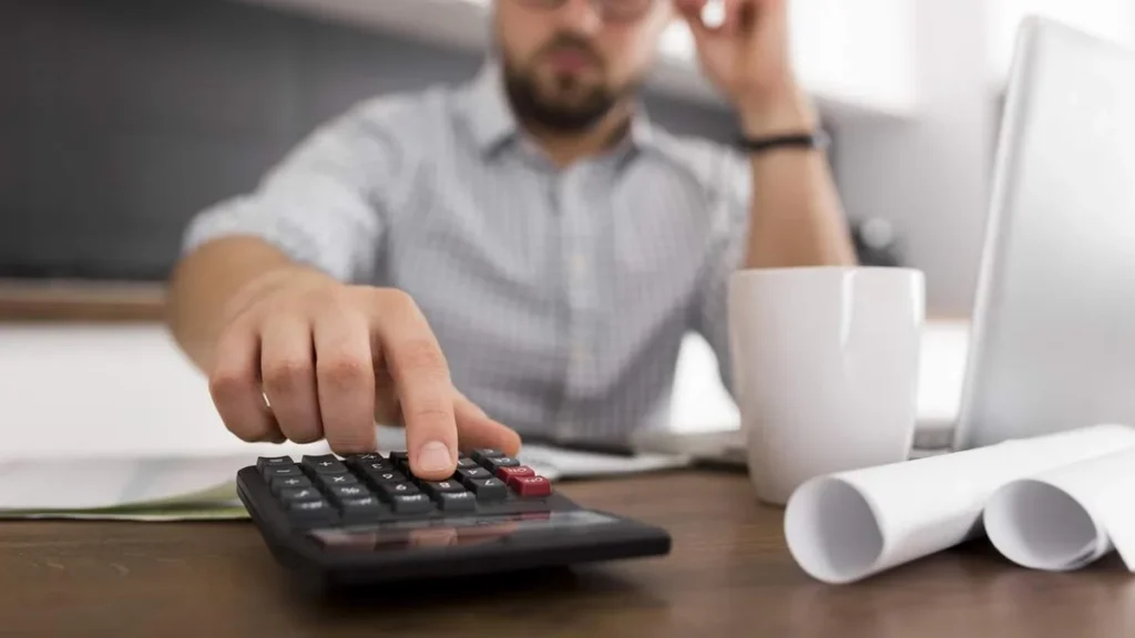 Imagem Homem preocupado fazendo as contas na calculadora do artigo Crédito fácil: o desafio do superendividamento no Brasil
