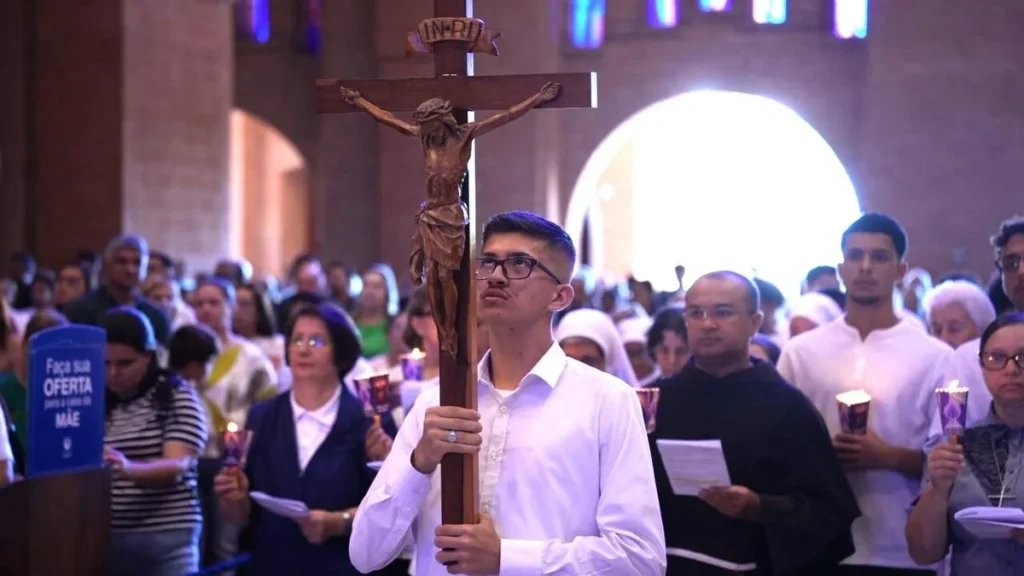 Imagem jovem com a Cruz na Via Sacra Santuario 2026 do artigo Via Sacra no Santuário: oração pela paz e dignidade