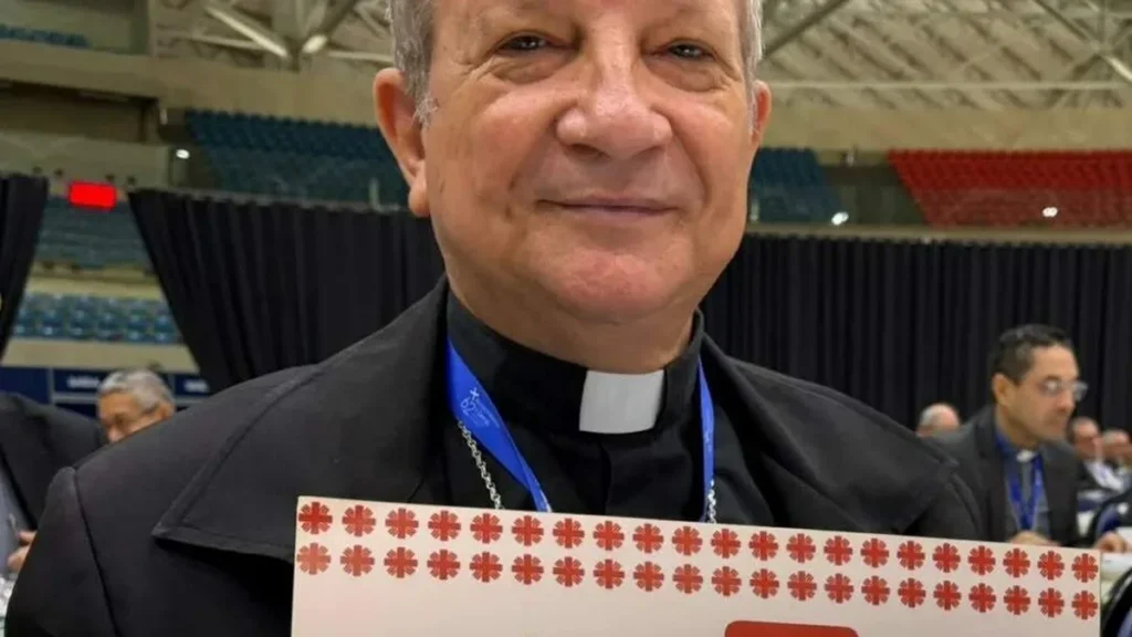 Imagem dom mario com cartaz da caritas do artigo Da Cáritas, Dom Mário traz a prática do Evangelho a Aparecida