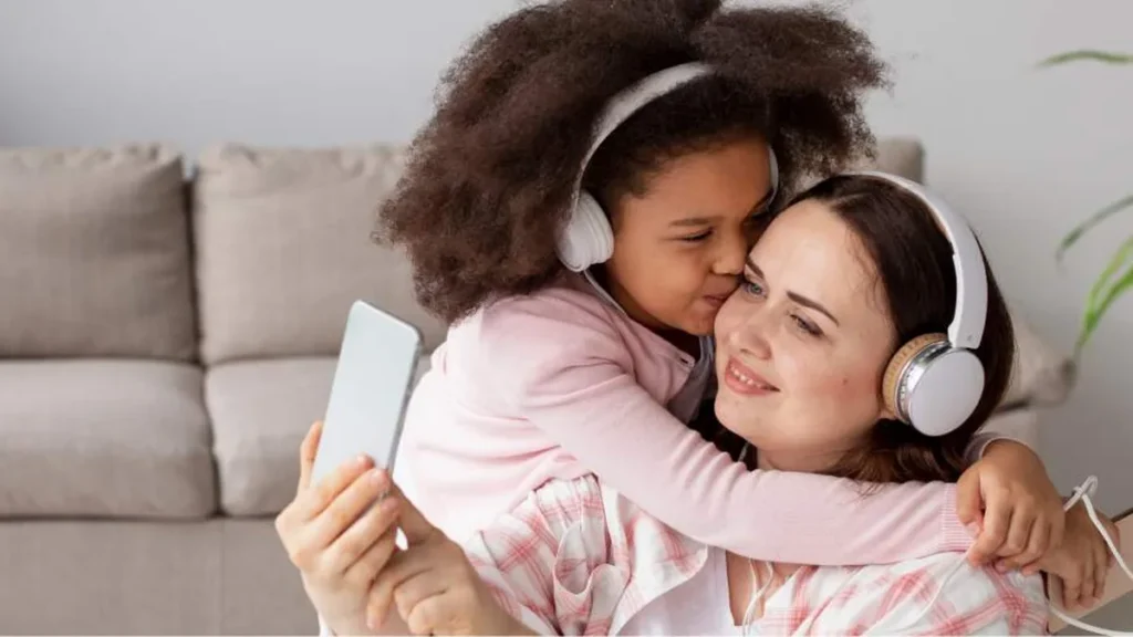 Imagem mae e filha abracadas ouvindo musica com fones de ouvido do artigo Celebre o Dia das Mães com músicas que atravessam gerações