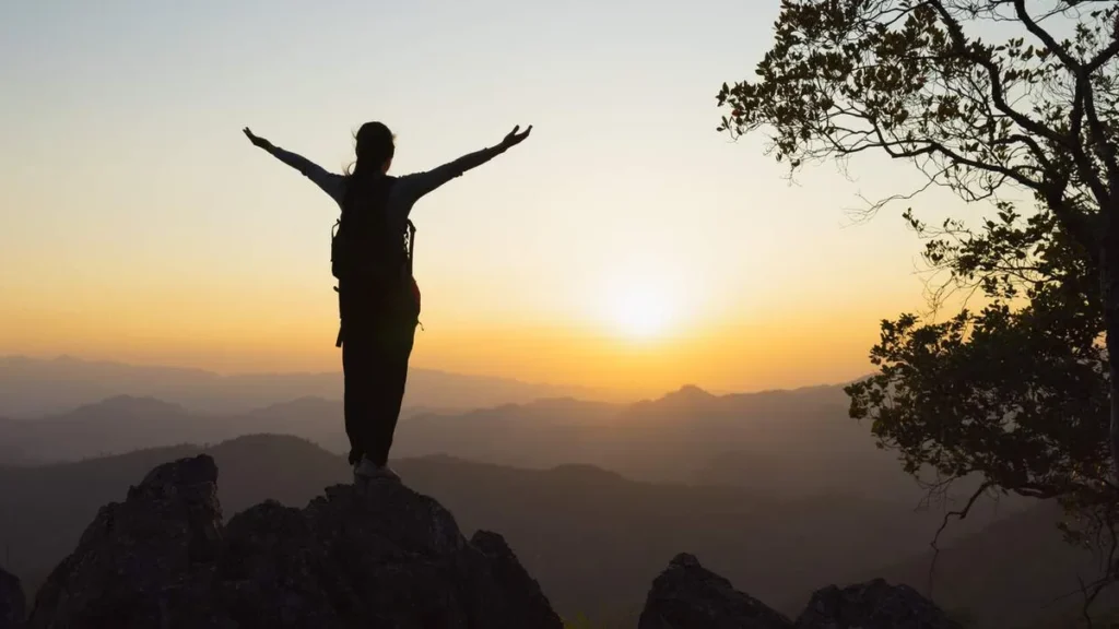 Imagem mulher com os bracos levantados para o horizonte do artigo Oração de filho feliz
