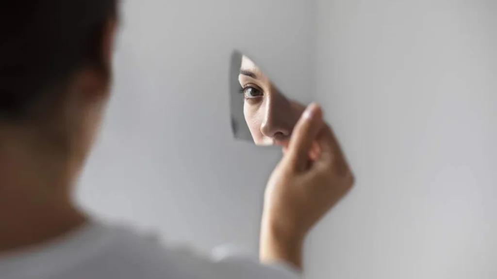 Imagem Mulher se olhando no espelho quebrado do artigo Autoconhecimento: o quanto você se conhece de verdade?